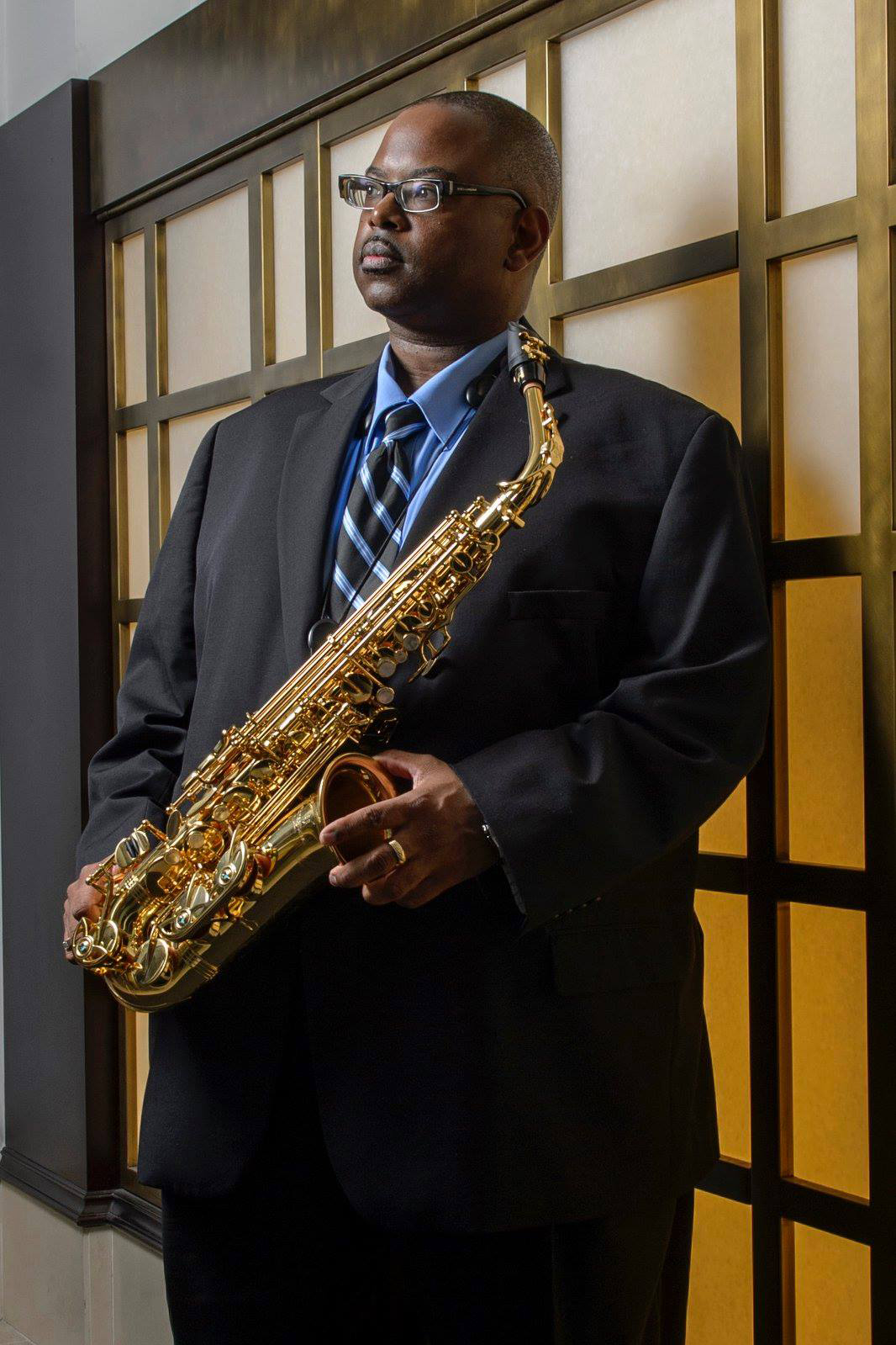 a headshot of Dave Clark holding an alto saxophone